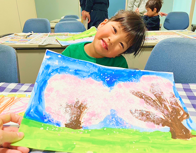 絵の具で描いた桜の絵と笑顔の生徒